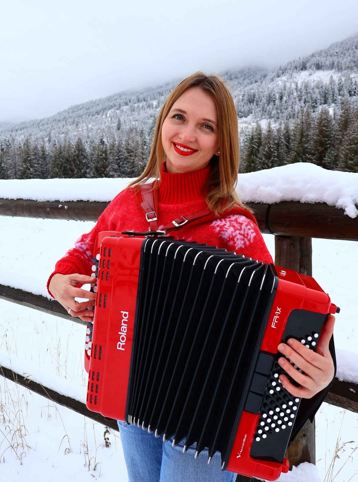 Iryna with her accordion in a snowy Okanagan forest.